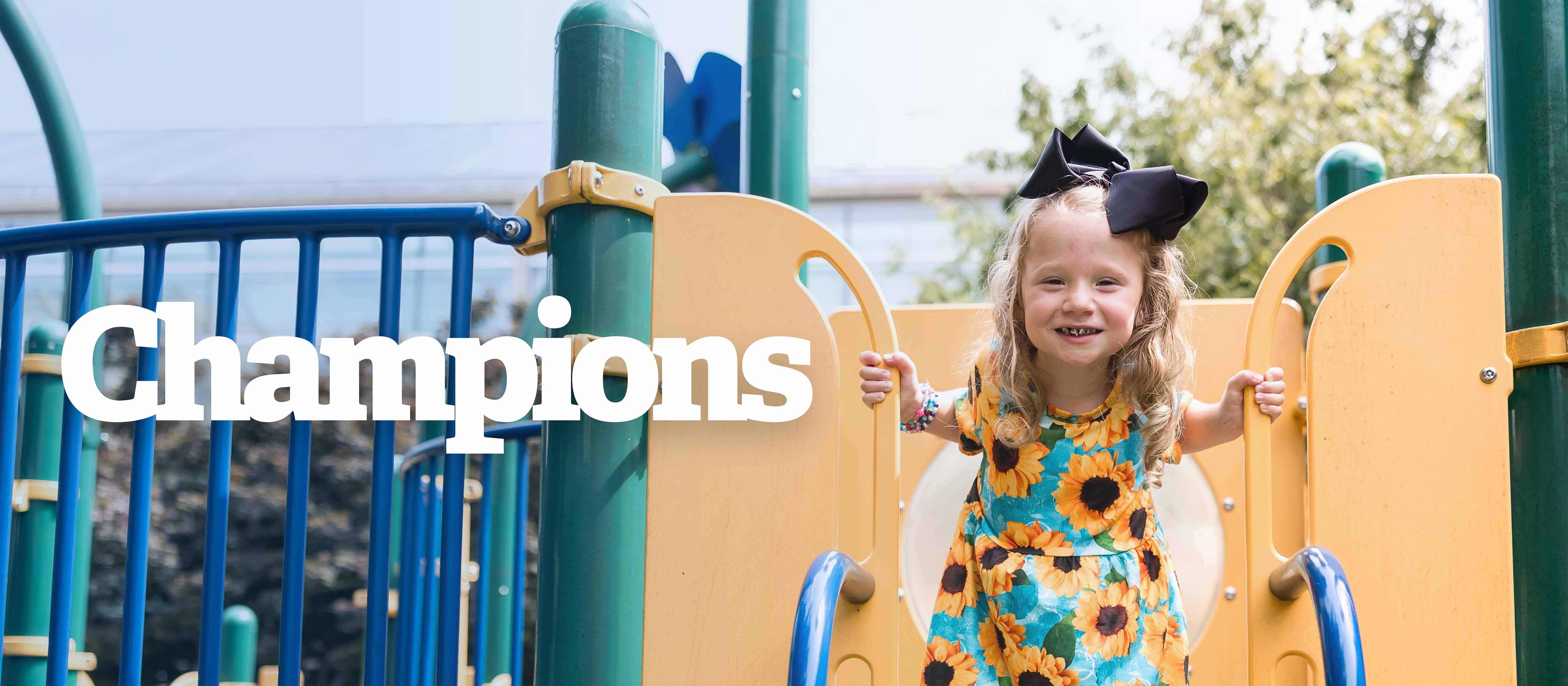 Girl on playset wearing sunflower dress.
