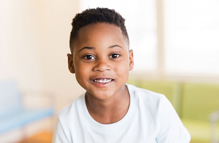 Boy in white tee shirt in clinic waiting room.