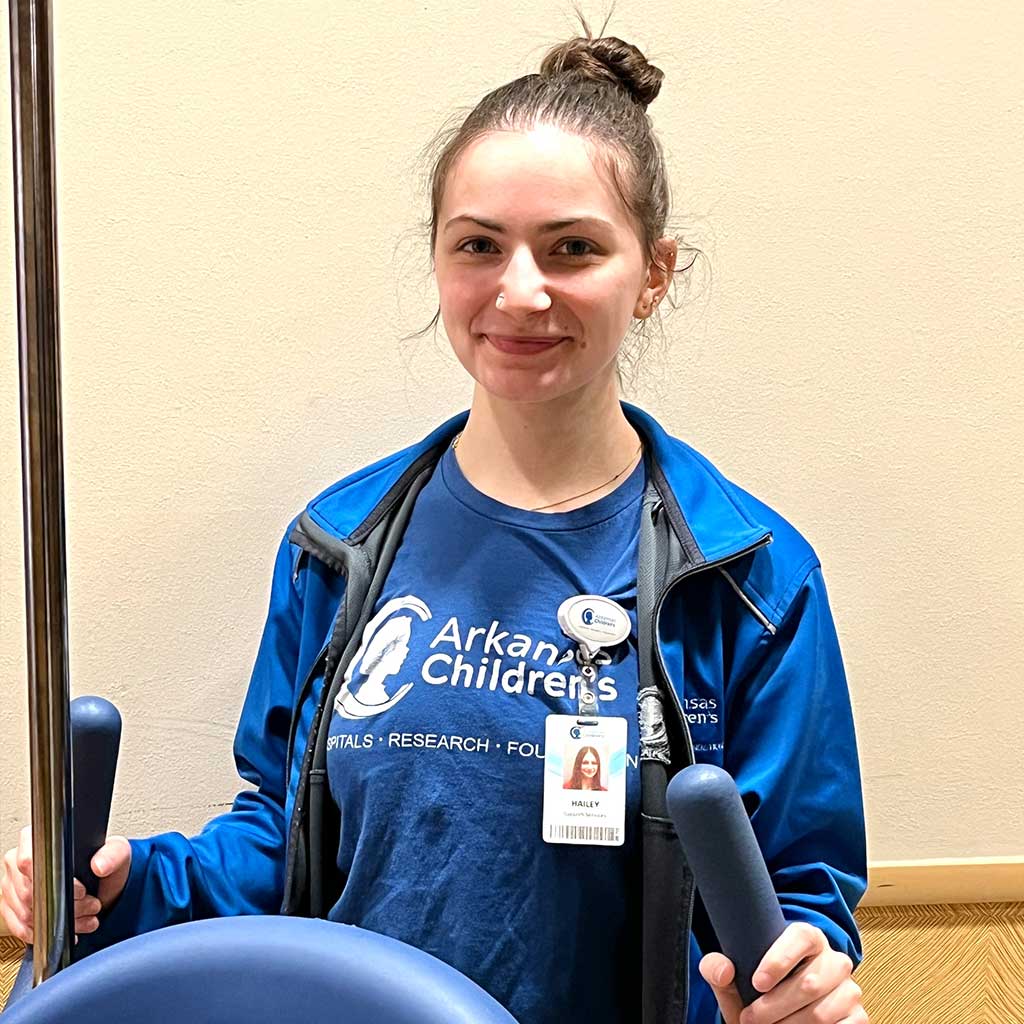 Smiling female employee in blue t-shirt.