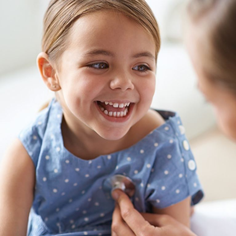 Girl in blue dress laughing.