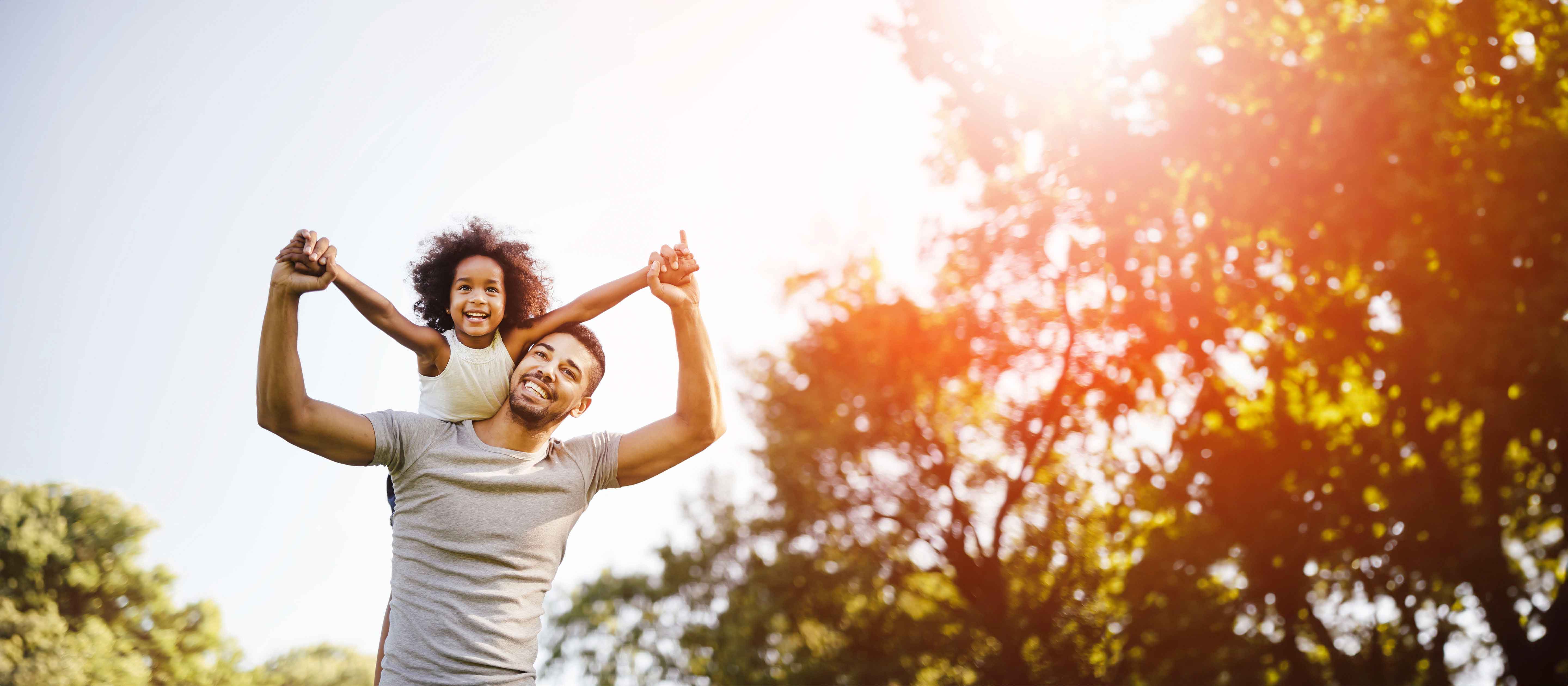 Dad and daughter playing in the sunlight.