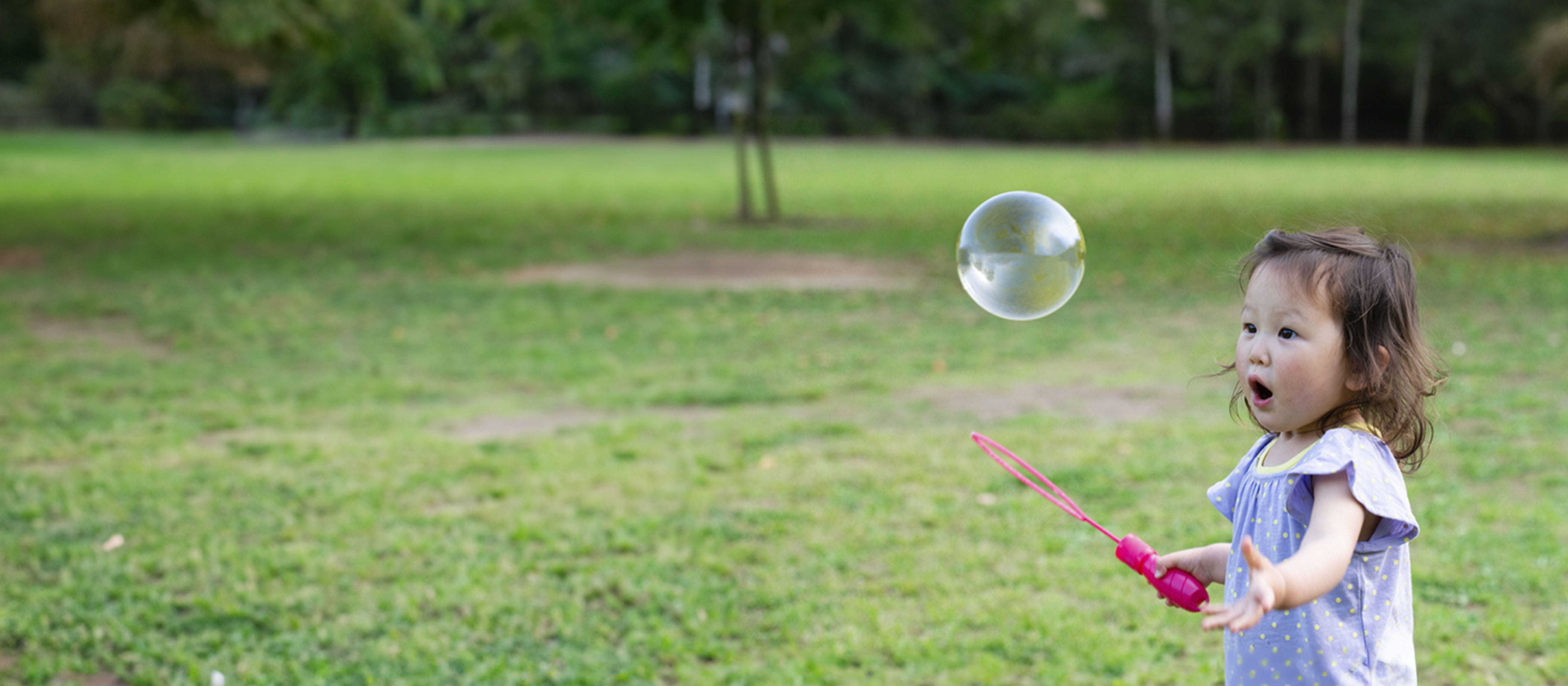 Girl outside blowing bubbles