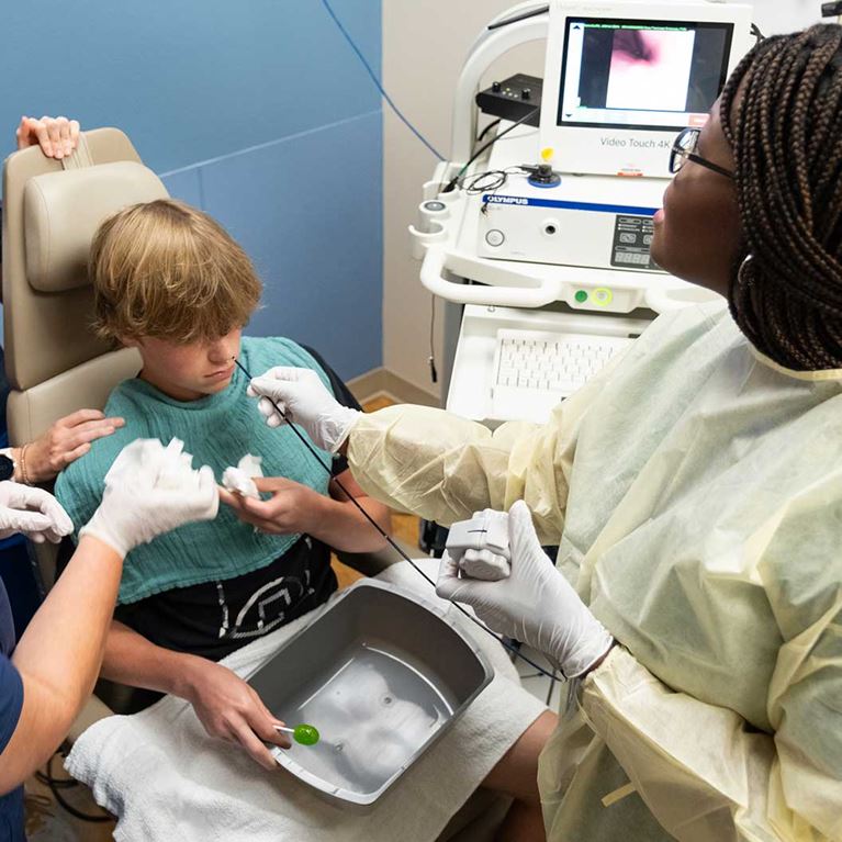 Blonde teenage male patient sitting down having procedure.