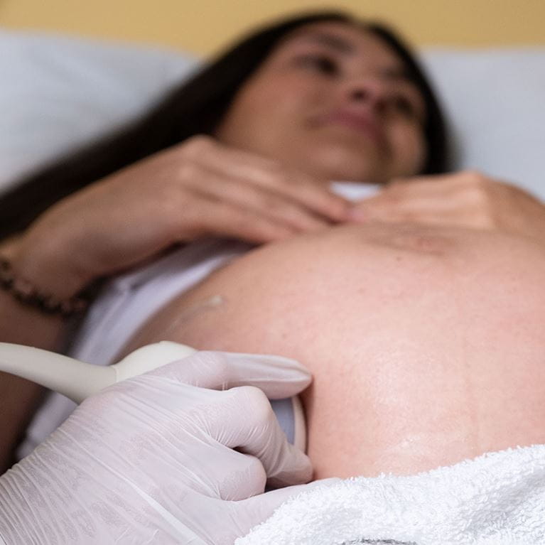 Pregnant woman receiving echo cardiogram.