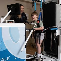 Male patient standing while using Rise and Walk machine.