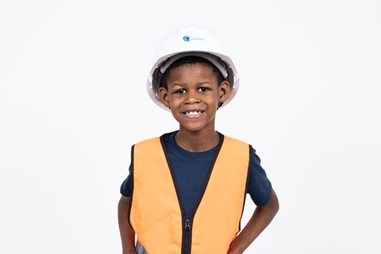 Adolescent male patient wearing hard hart and orange vest.