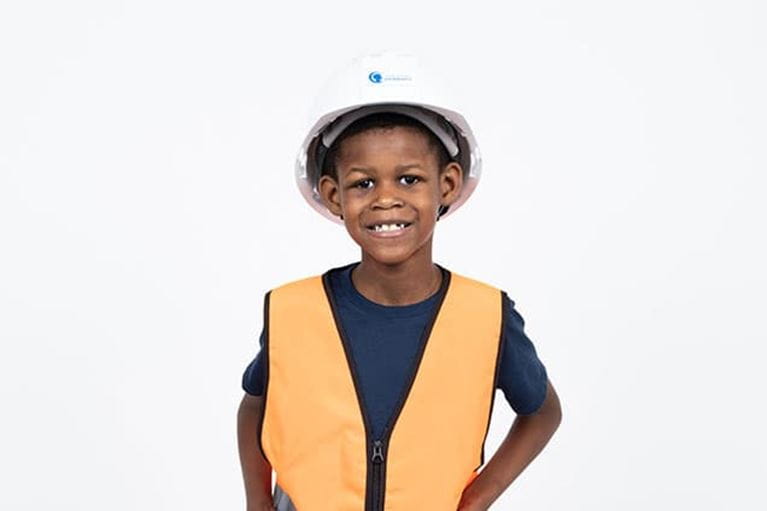 Adolescent male patient wearing hard hart and orange vest.