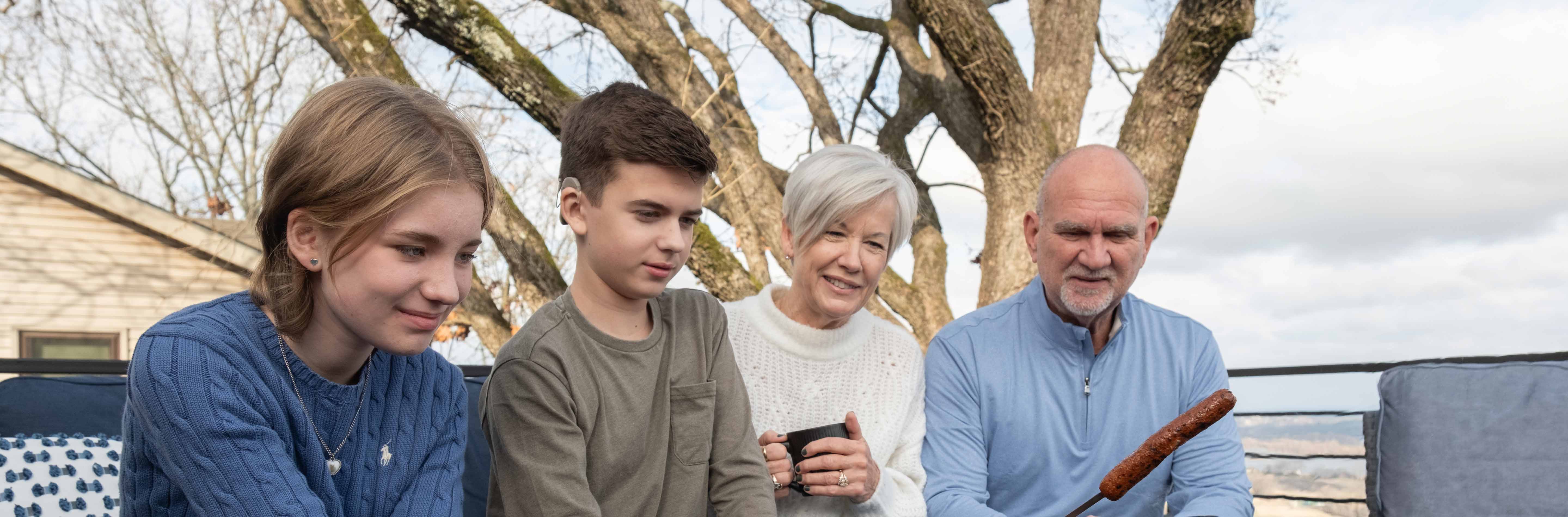 Grandparents sitting outside by the fire with grandchildren.