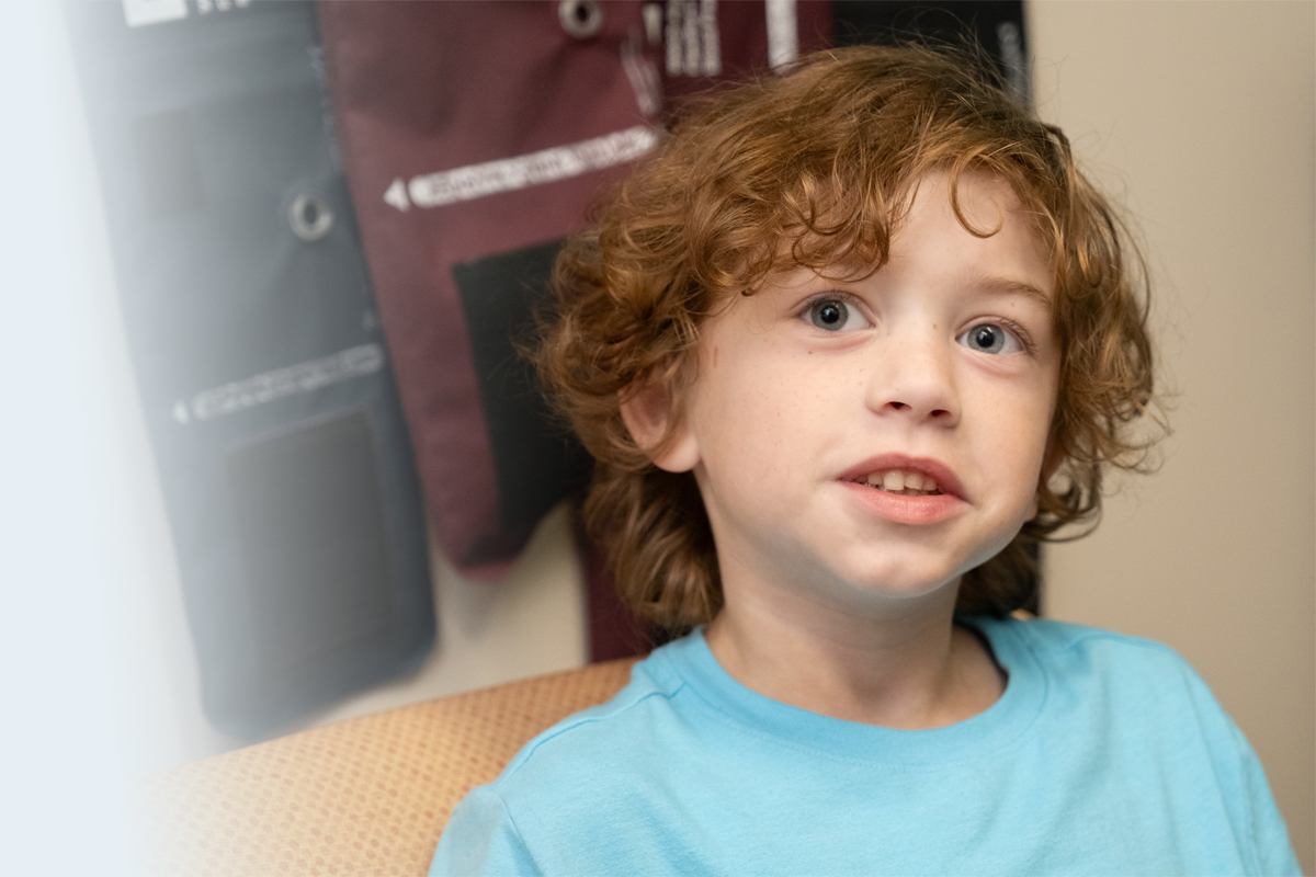 Patient wearing blue shirt sitting in clinic chair. 