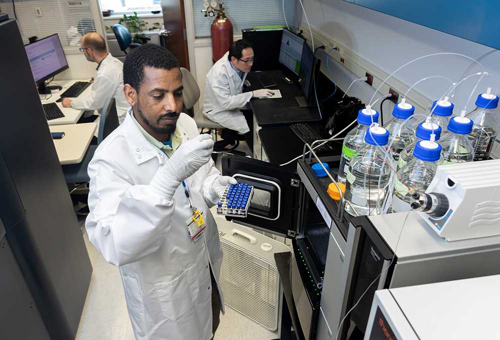 Photo of a researcher in white lab coat.