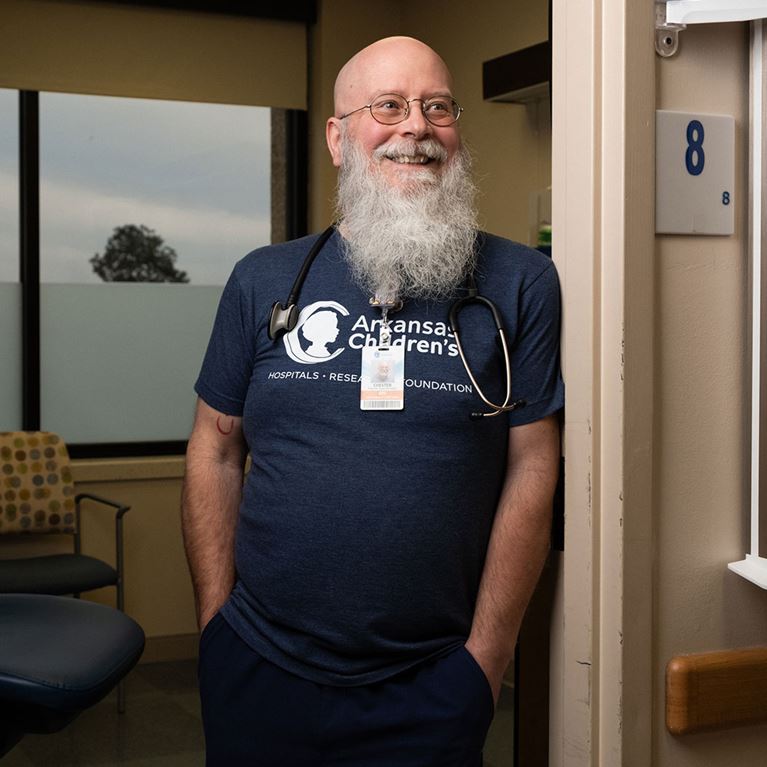 Male nurse standing in doorway of clinic room.