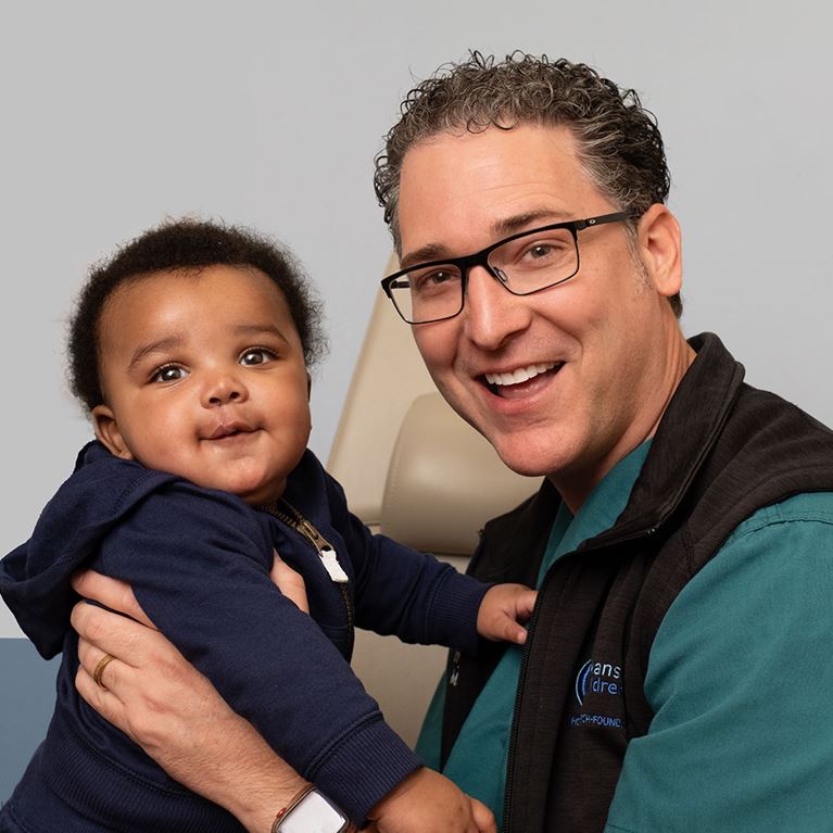 Dr. Hartzell holding small patient in clinic.