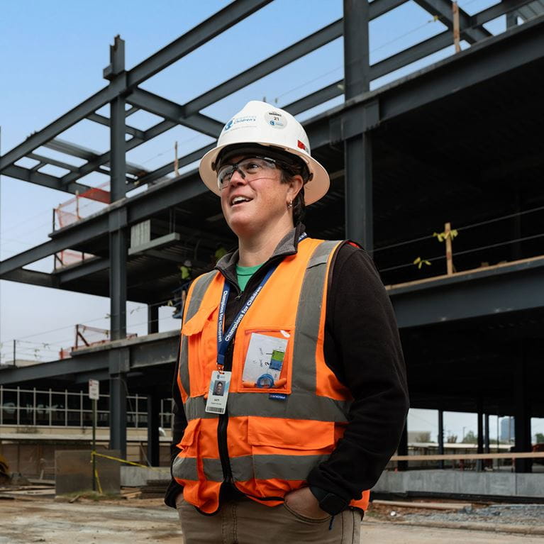 Senior project manager standing outside in construction area.