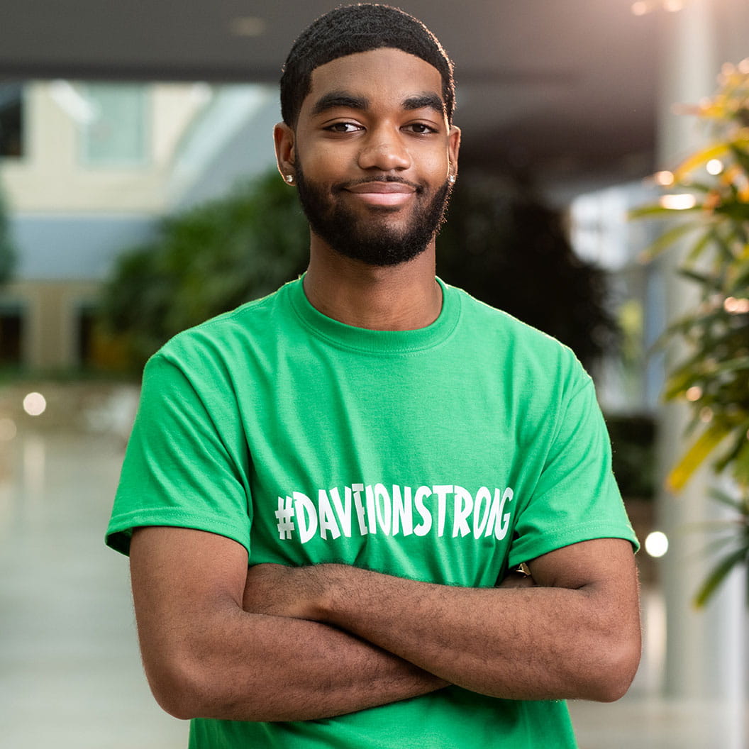 Teenage male patient wearing green shirt posing in atrium.
