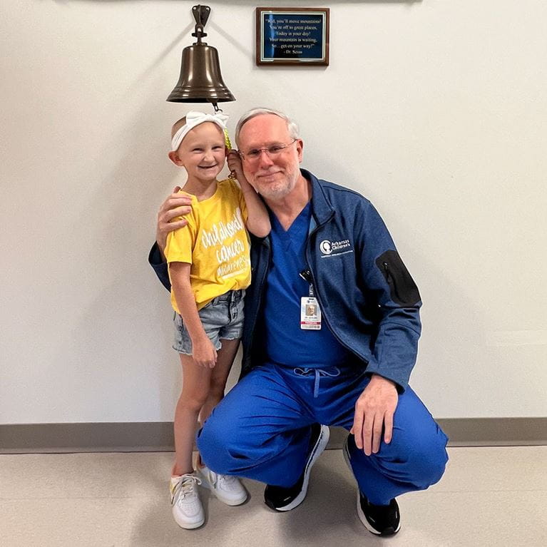 Female oncology patient ringing the bell with Dr. Saylors.