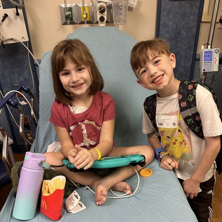 Two school-aged patients smiling at camera.