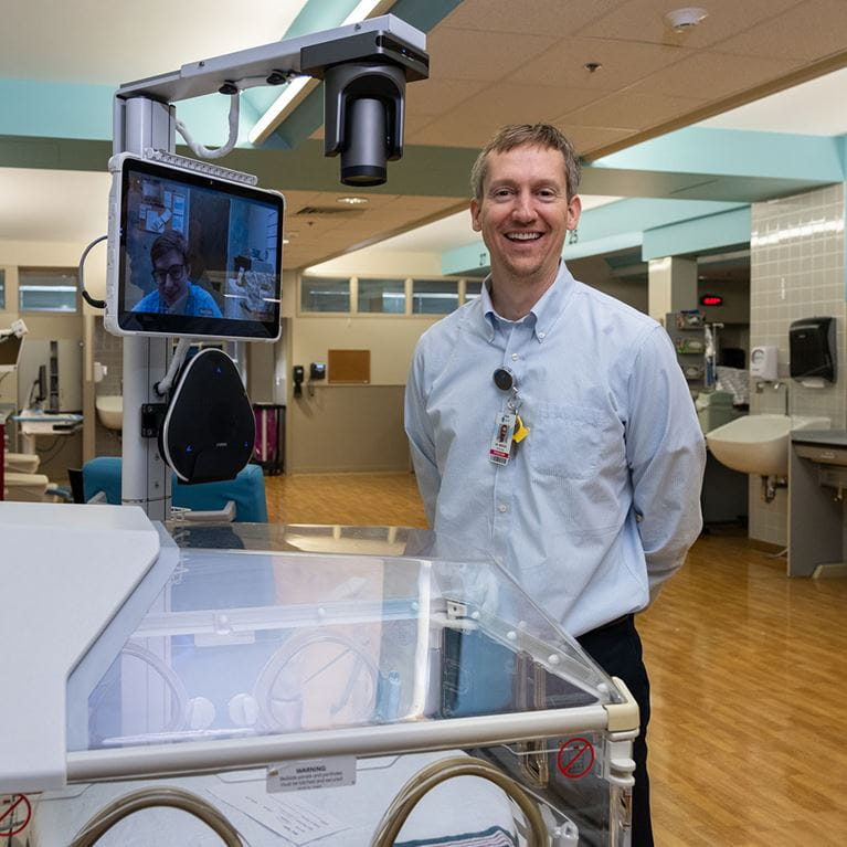 Dr. Merves standing beside the TeleNICU care.