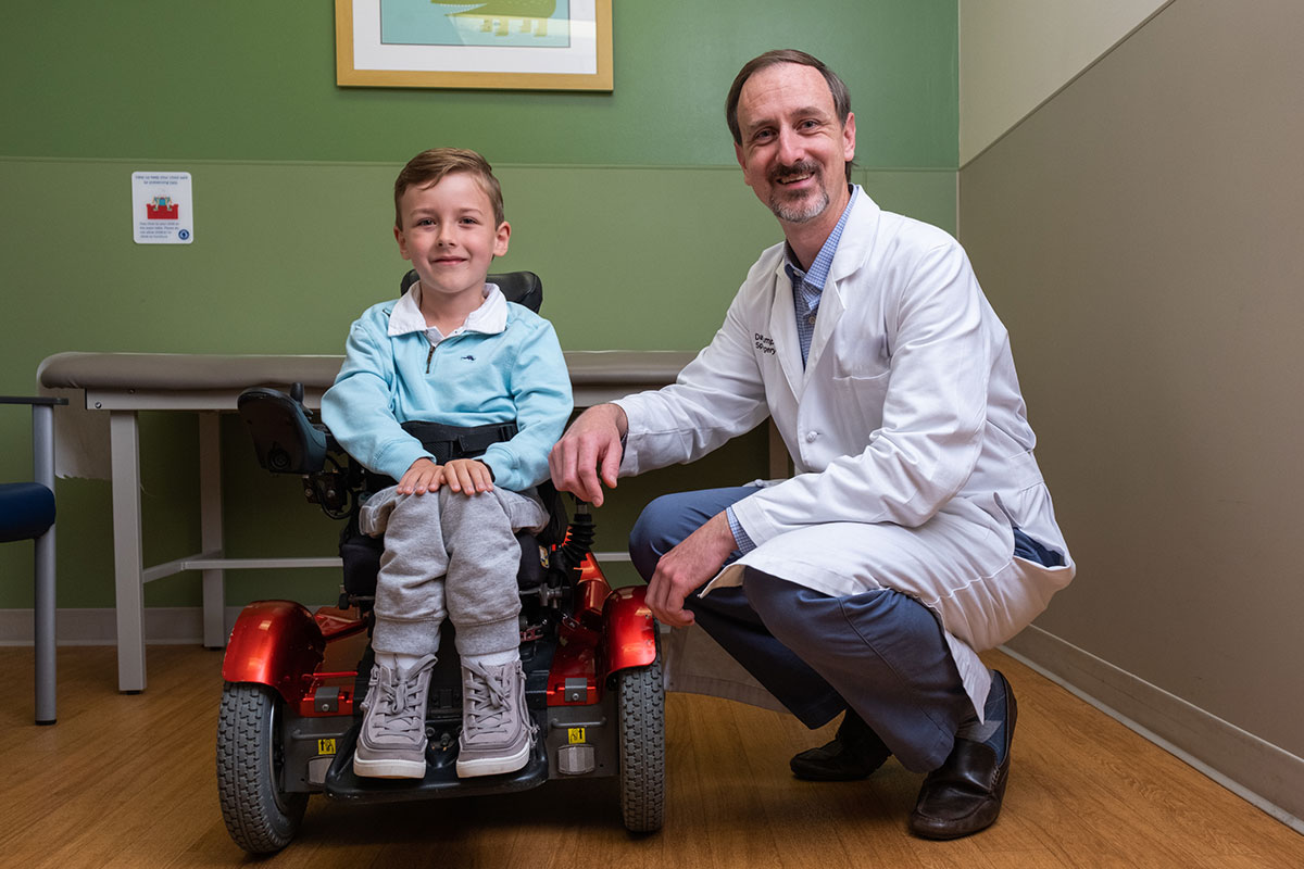 Patient wearing blue shirt beside physician.