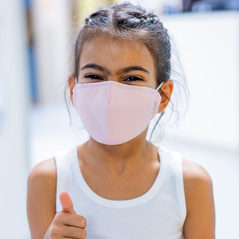 Masked girl giving thumbs up