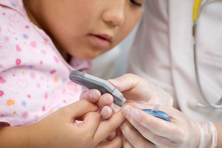 Child checking her blood sugar