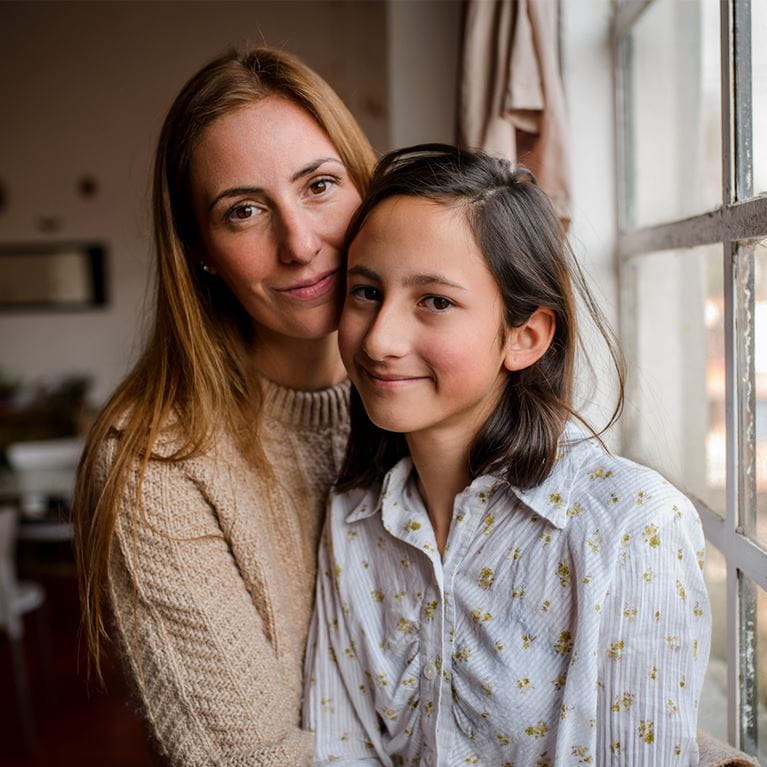 Mom and daughter sitting next two window