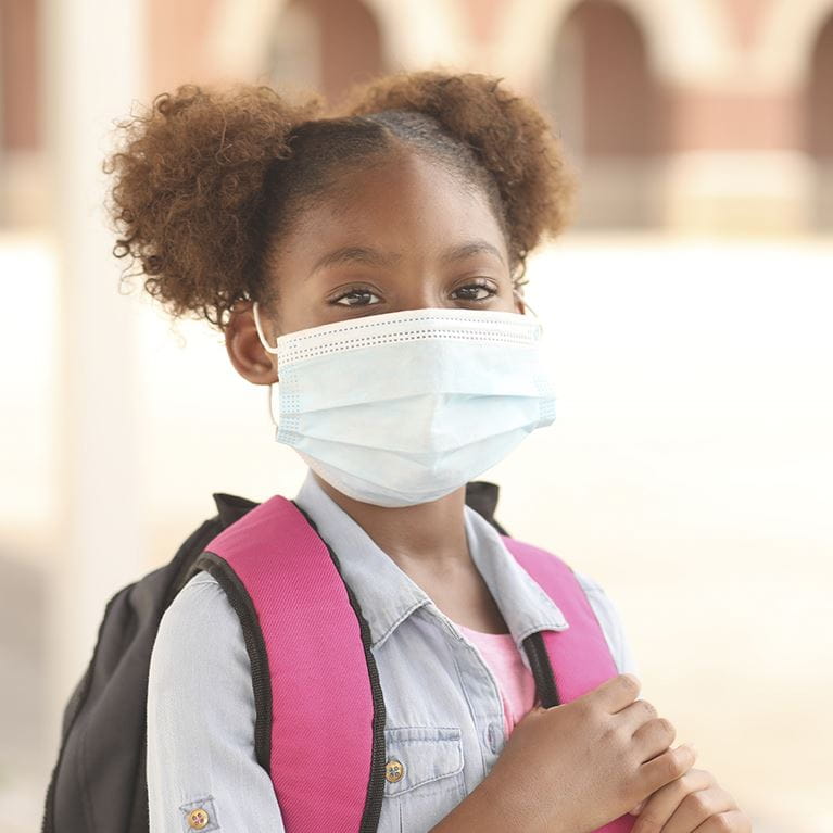 Child with backpack and mask