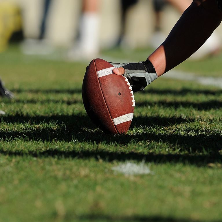 A football player gets ready to hike a football.