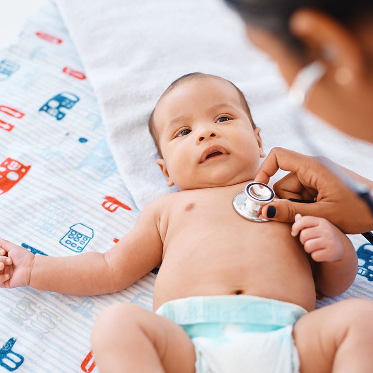 Infant getting checkup with doctor.