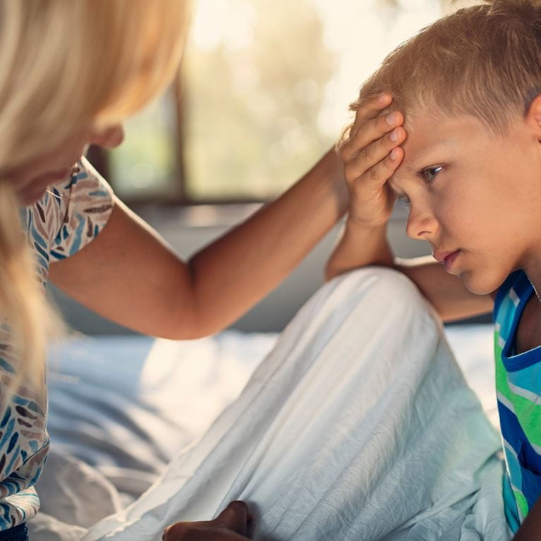 Boy with headache sitting with parent