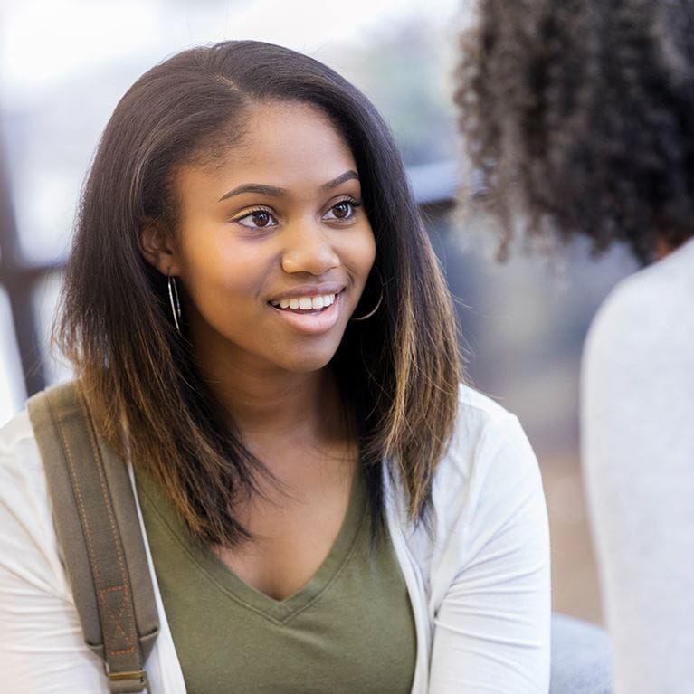 Teenage girl talking to adult