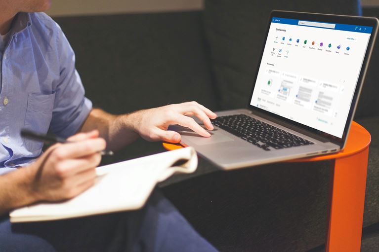 Image of a man on a computer using Office 365.