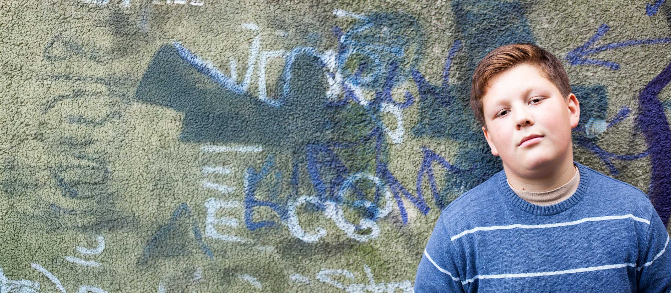 Boy leaning against a wall.