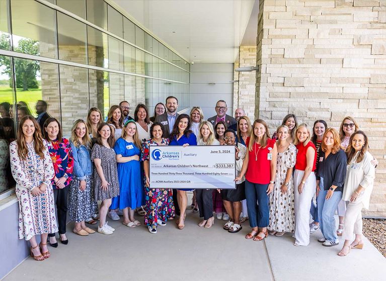 A group of people holding a very large check for presentation.