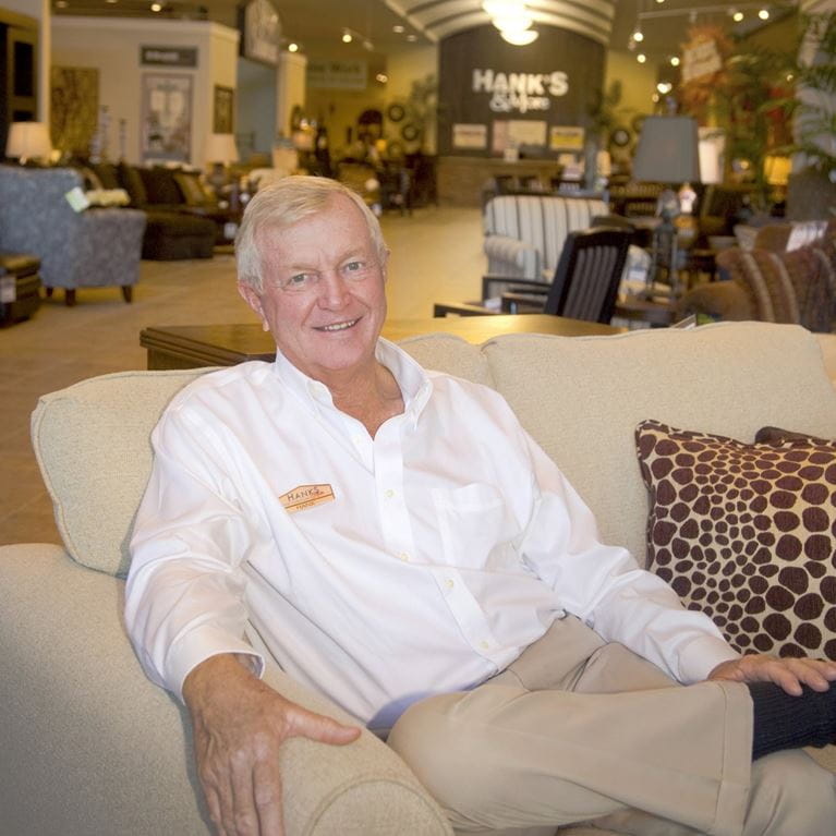 Photo of Hanke Browne sitting on sofa at furniture store wearing white shirt
