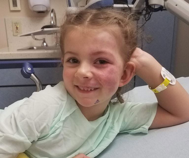 ACH patient, Faith, smiles at the camera.