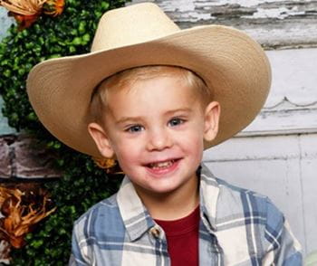 Arkansas Children's patient, Ace, is wearing a cowboy hat.