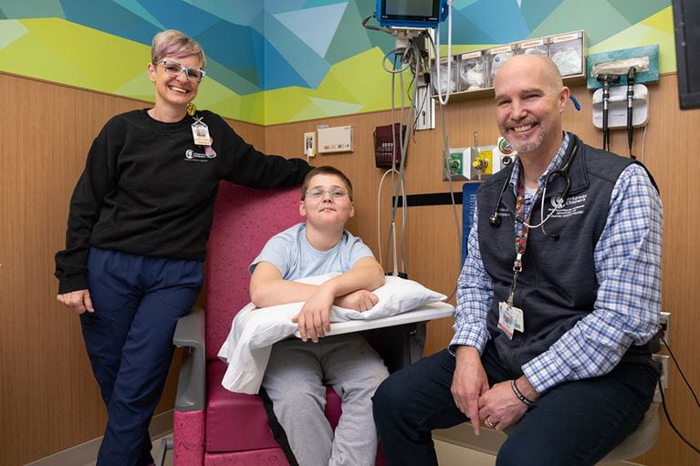 Photo of patient, Jessie White, Dr. Oden and nurse in doctor's office.