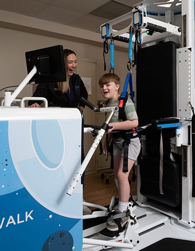 Smiling boy standing up using Rise and Walk Machine