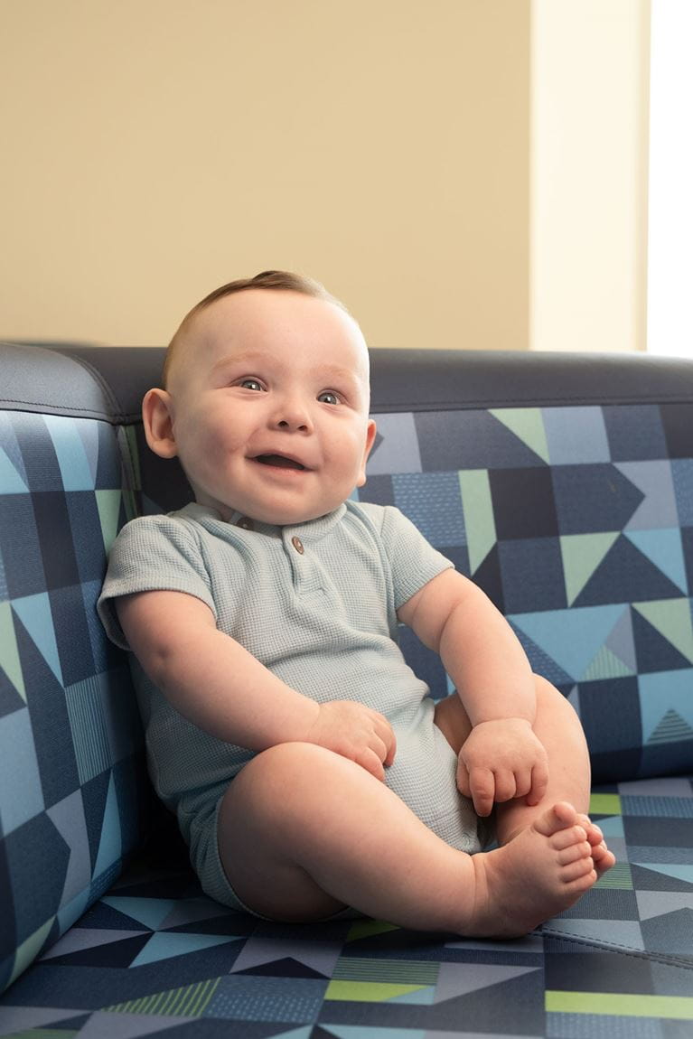 Baby boy wearing blue onesie and red hair
