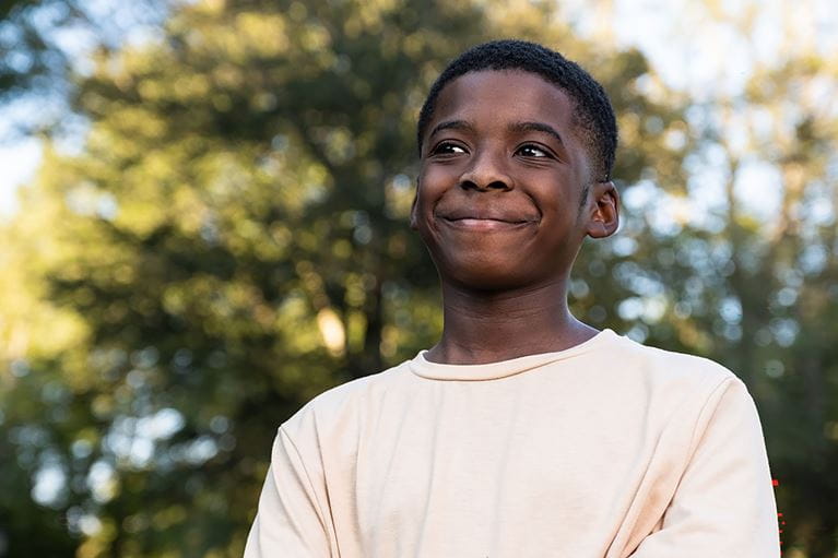Smiling Arkansas Children's teenage patient in a park.